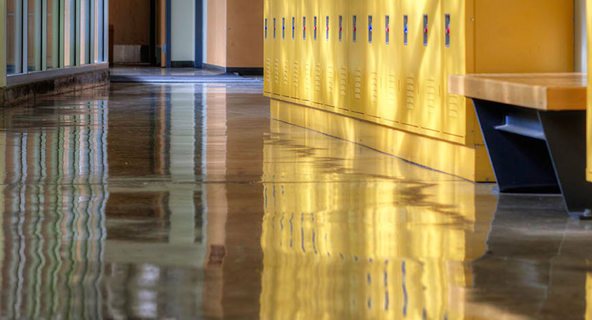 A shiny floor in a hallway of yellow lockers