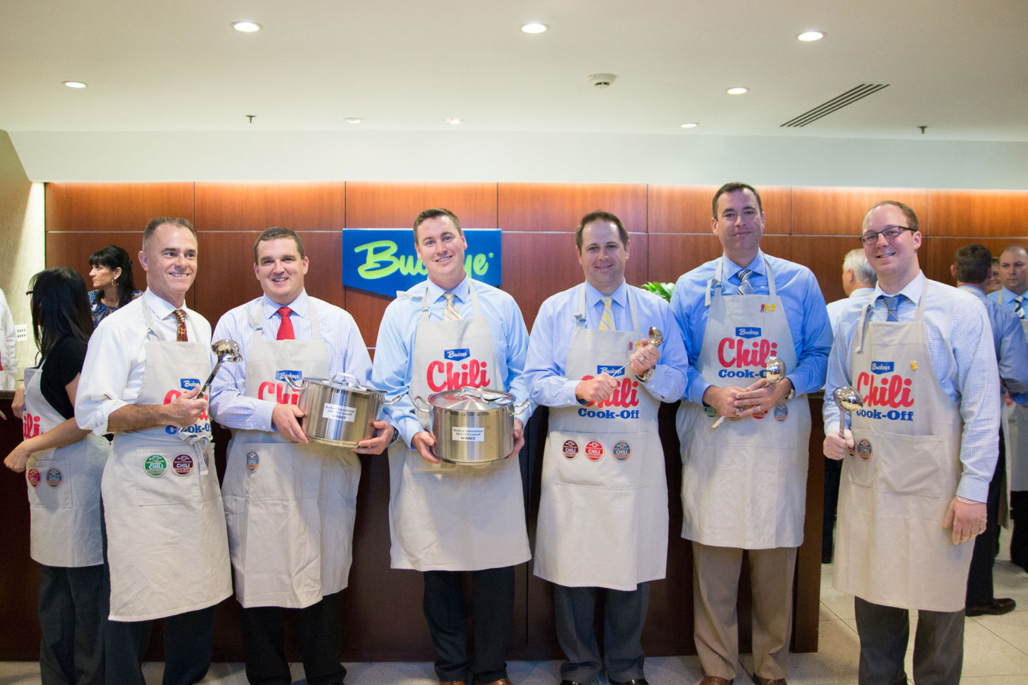 Winners of the Buckeye Chili Cookoff lined up in the lobby holidng stainless pots and laddles as their trophys.