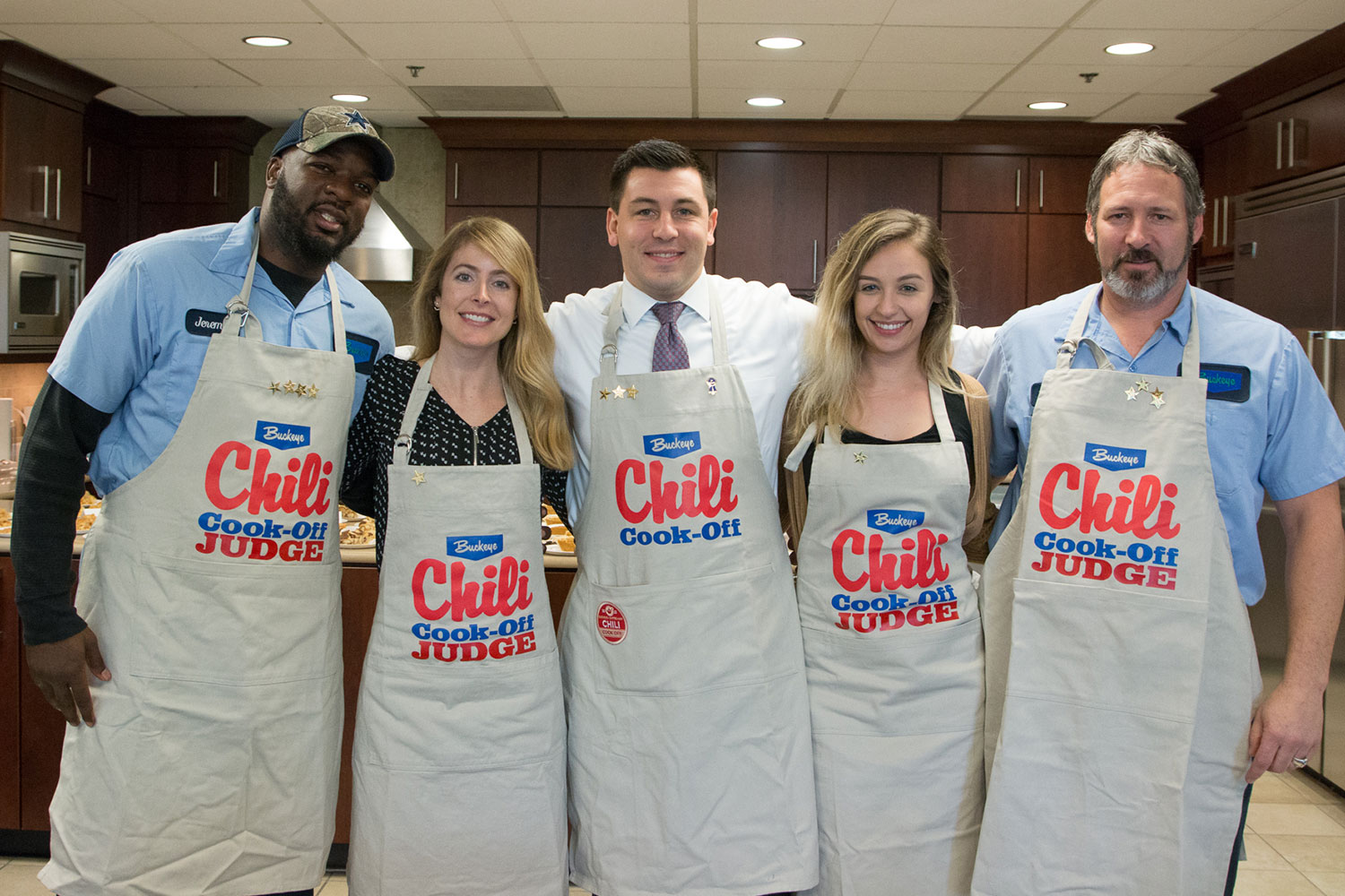 Buckeye employees in the kitchen wearing aprons that say Buckeye Chili Cook-Off Judge