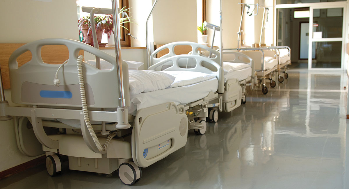 A hallway of empty hospital beds