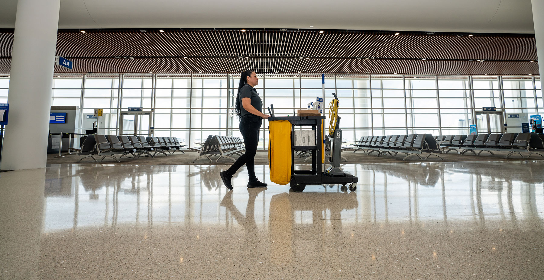 Woman pushing a Janitorial cart at the New Orleans airport