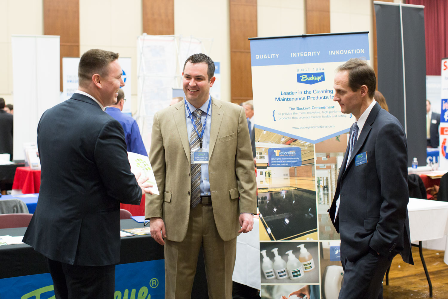 Three men talking at a career fair.