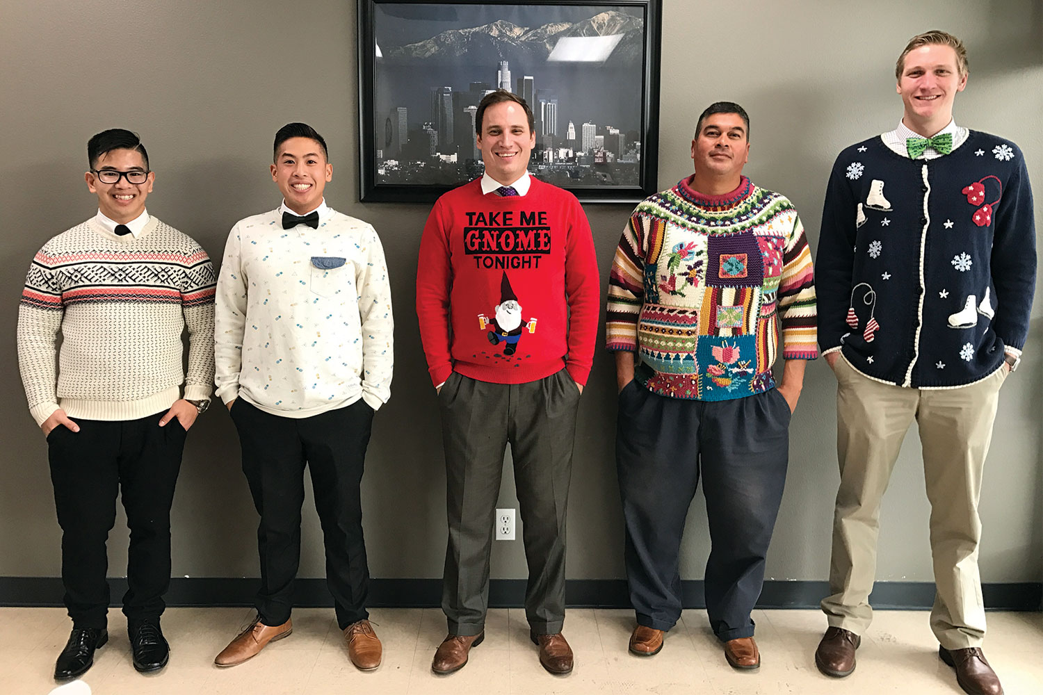Five members of the sales team smiling and wearing their holiday sweaters.