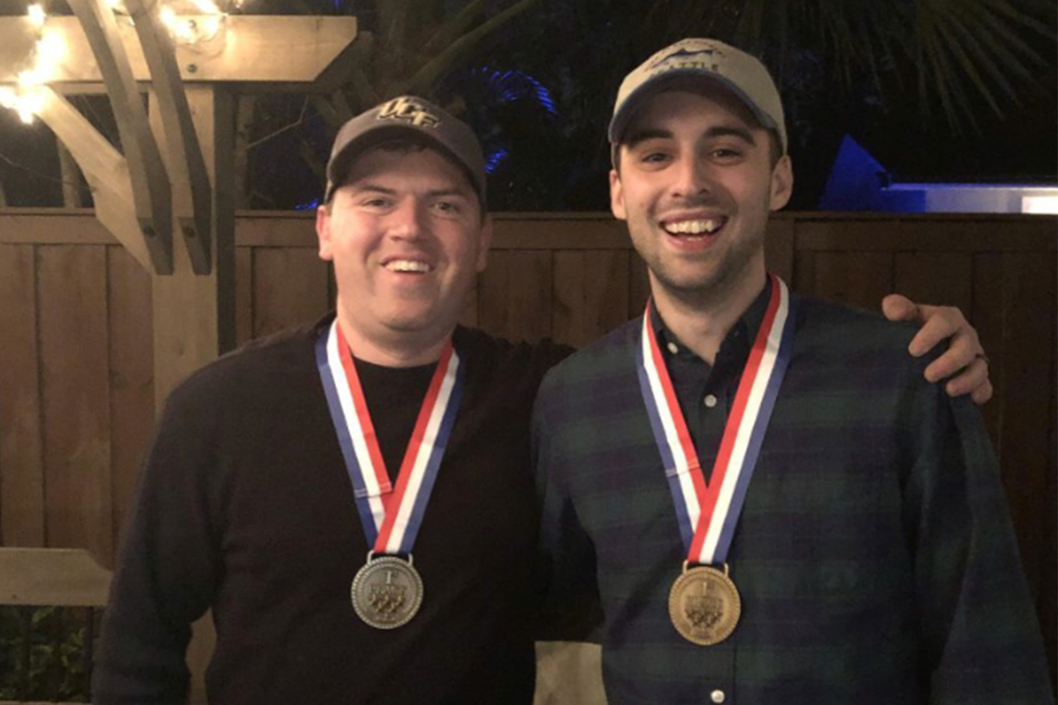 Two men with gold medals around their necks.