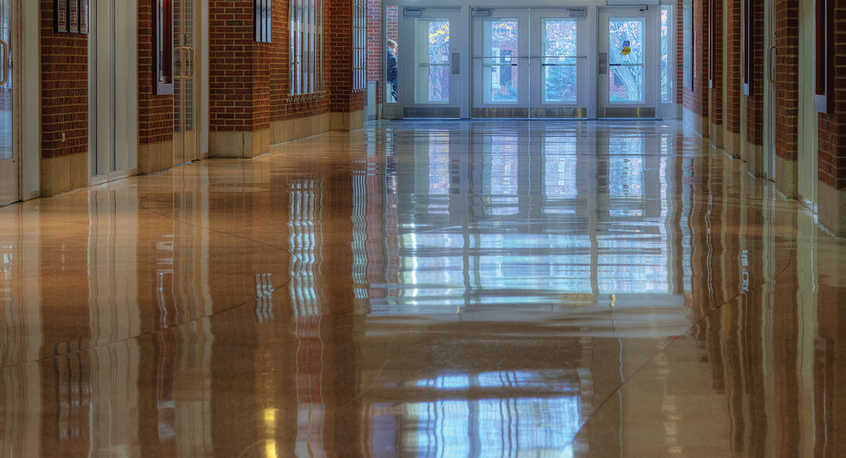 A shiny floor reflecting light coming in from entrance doors